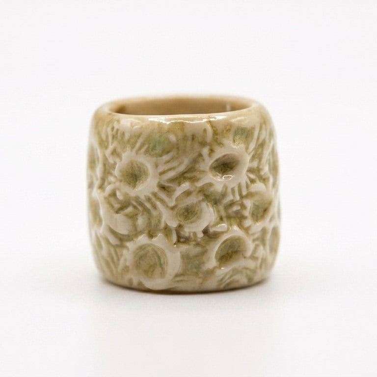Coral Fosilizado — anillo de porcelana crema con textura de coral sobre fondo blanco, vista frontal