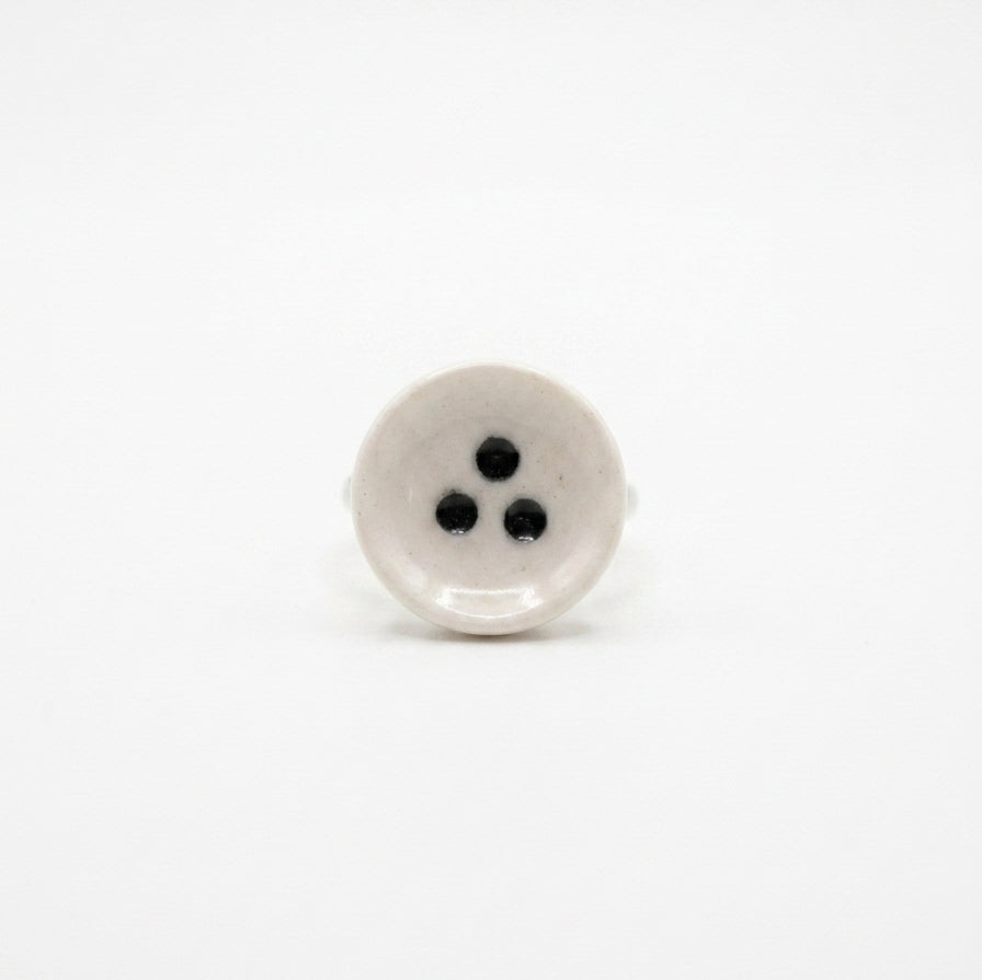 Nidus — anillo de porcelana en mano, fondo neutro
