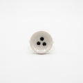 Nidus — anillo de porcelana en mano, fondo neutro