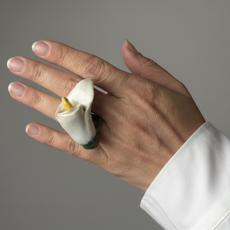 Cala — anillo de porcelana con flor de cala blanca en mano cerrada con camisa blanca, fondo gris