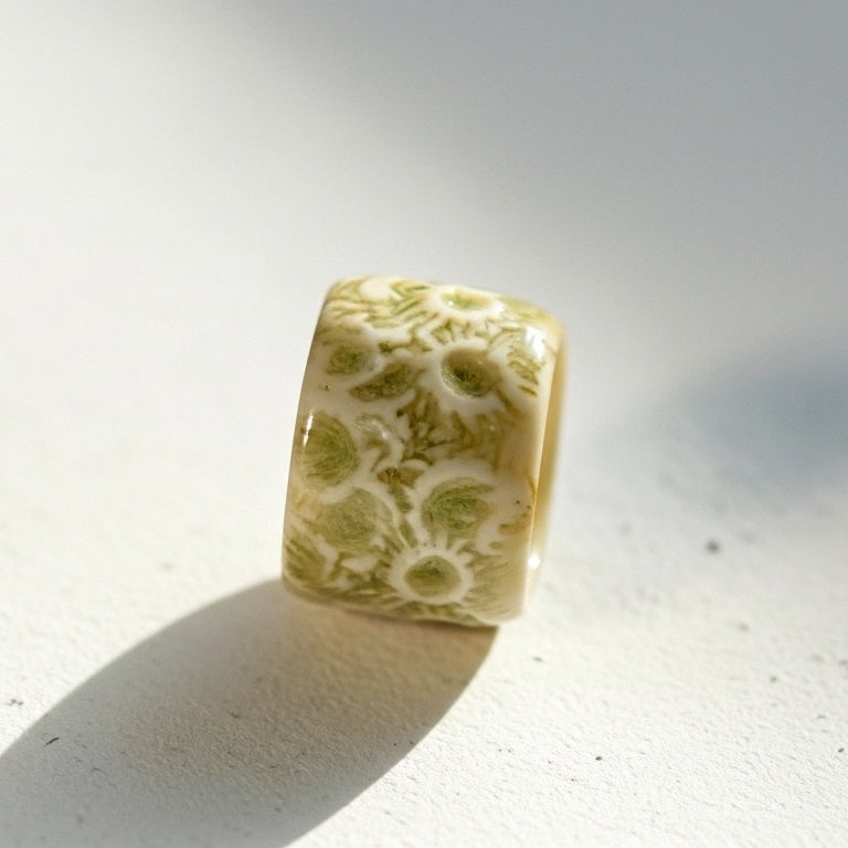 Coral Fosilizado — anillo de porcelana crema con textura de coral sobre superficie blanca con sombra solar