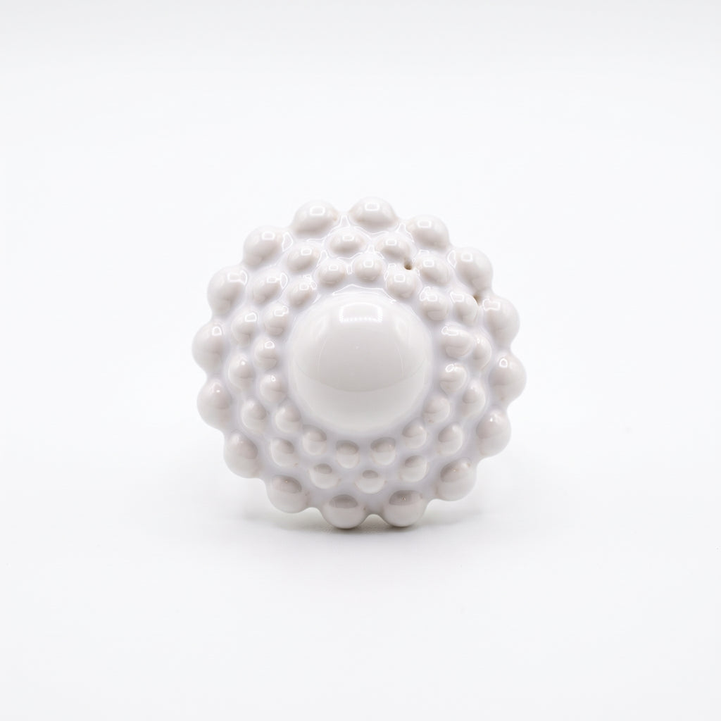 Girándola Blanco Nacarado — vista frontal del anillo de porcelana blanca monocromática con bultos y centro liso, fondo blanco