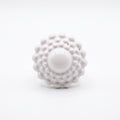 Girándola Blanco Nacarado — vista frontal del anillo de porcelana blanca monocromática con bultos y centro liso, fondo blanco