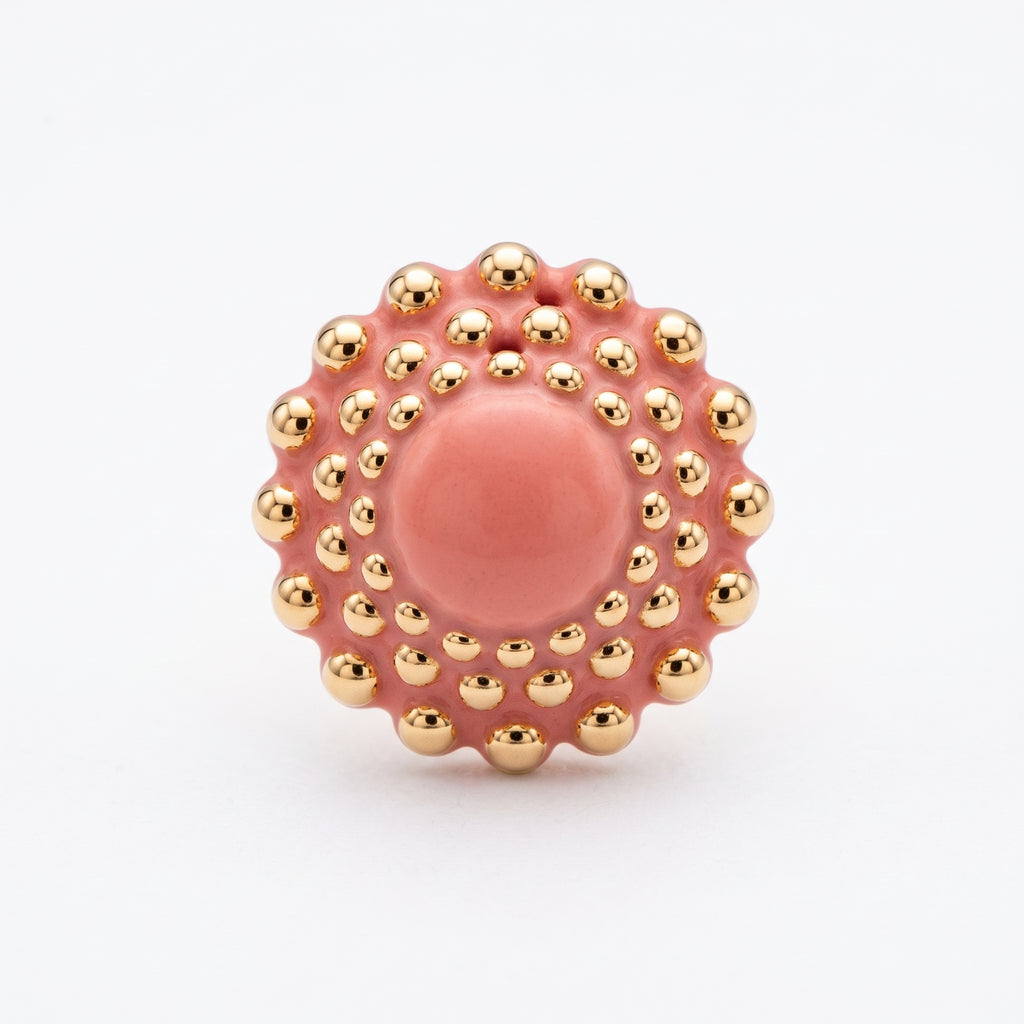 Girándola Coral — vista frontal del anillo de porcelana coral con bultos dorados y centro liso, sobre fondo blanco