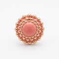 Girándola Coral — vista frontal del anillo de porcelana coral con bultos dorados y centro liso, sobre fondo blanco