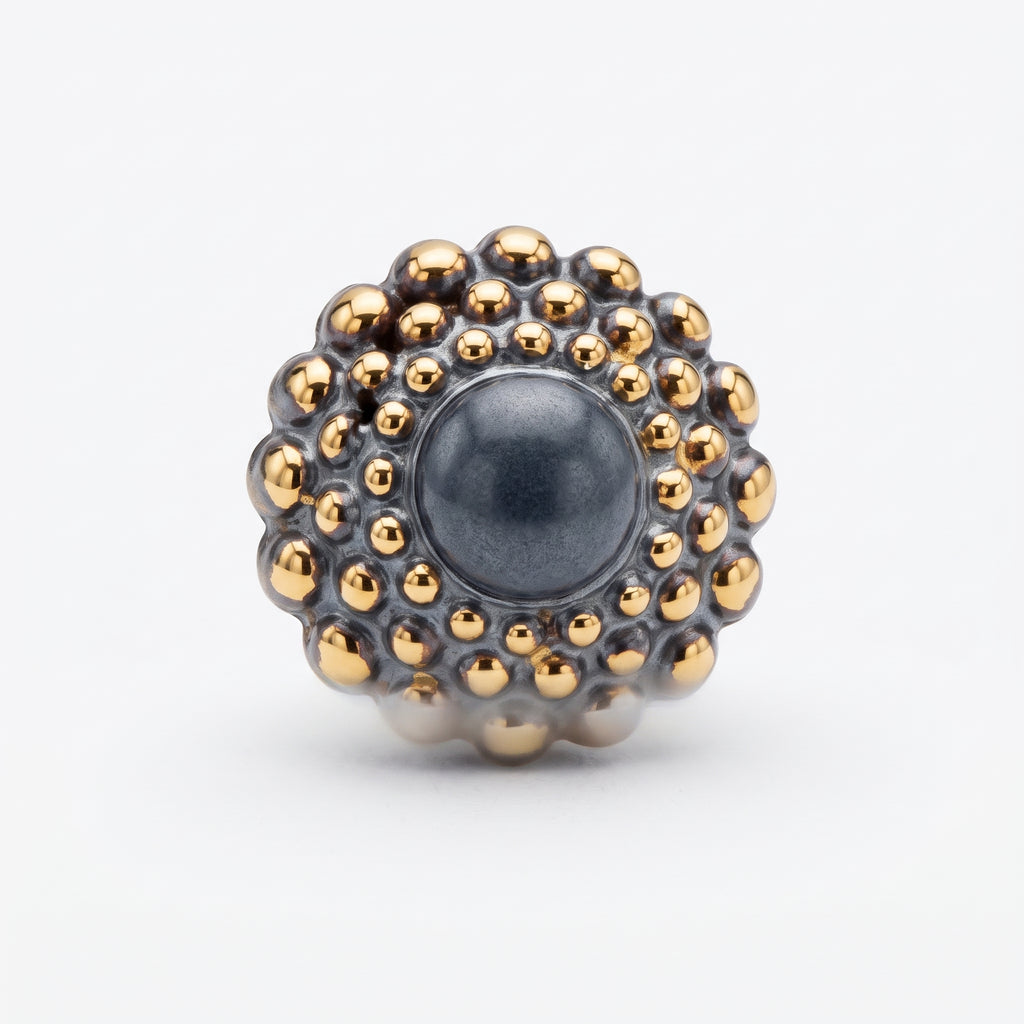 Girándola Pizarra Oro — vista frontal del anillo de porcelana gris pizarra con bultos dorados y centro gris mate, fondo blanco