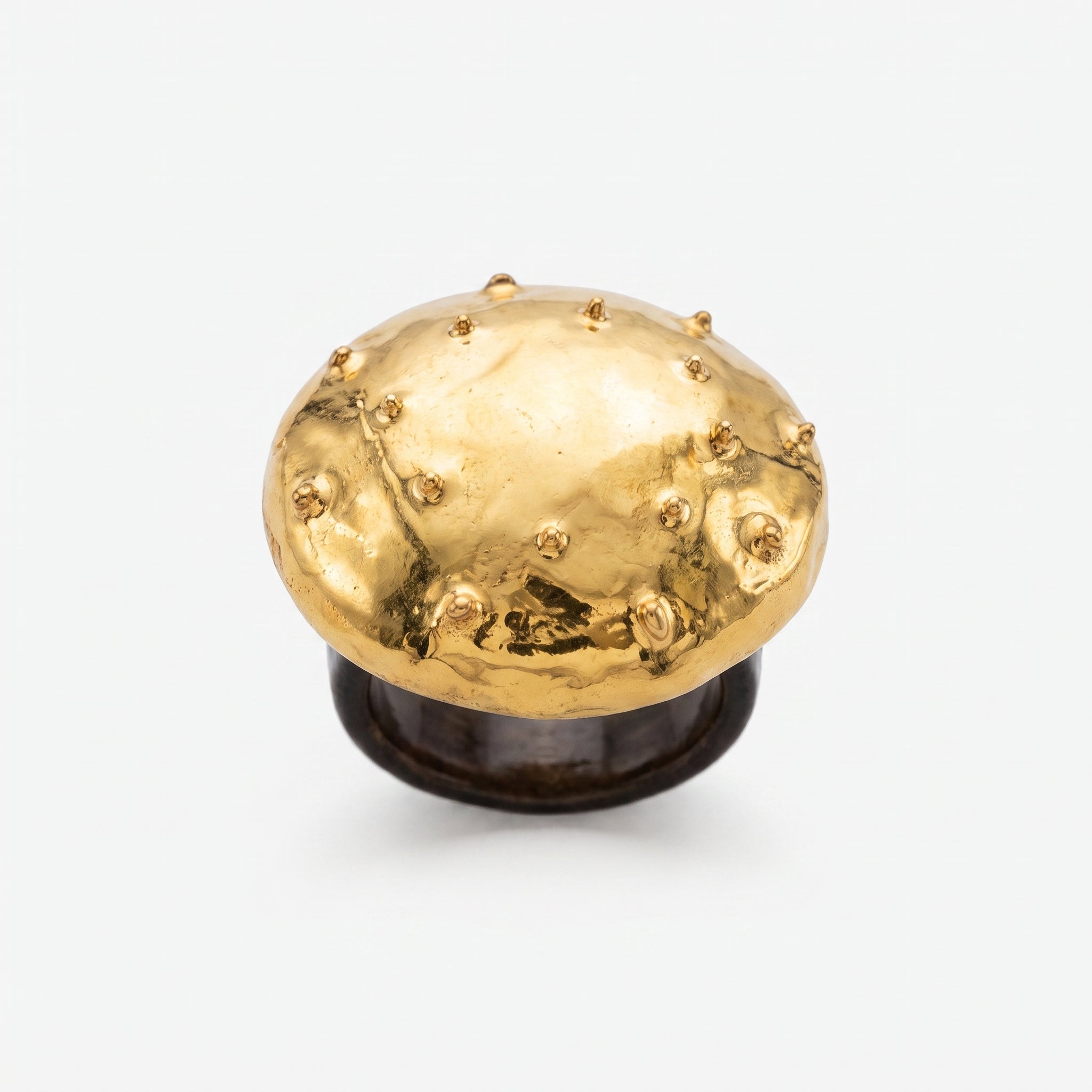Erizo Dorado — anillo de porcelana con cúpula dorada y púas esféricas sobre base negra mate, vista frontal sobre fondo blanco mostrando el contraste oro y negro