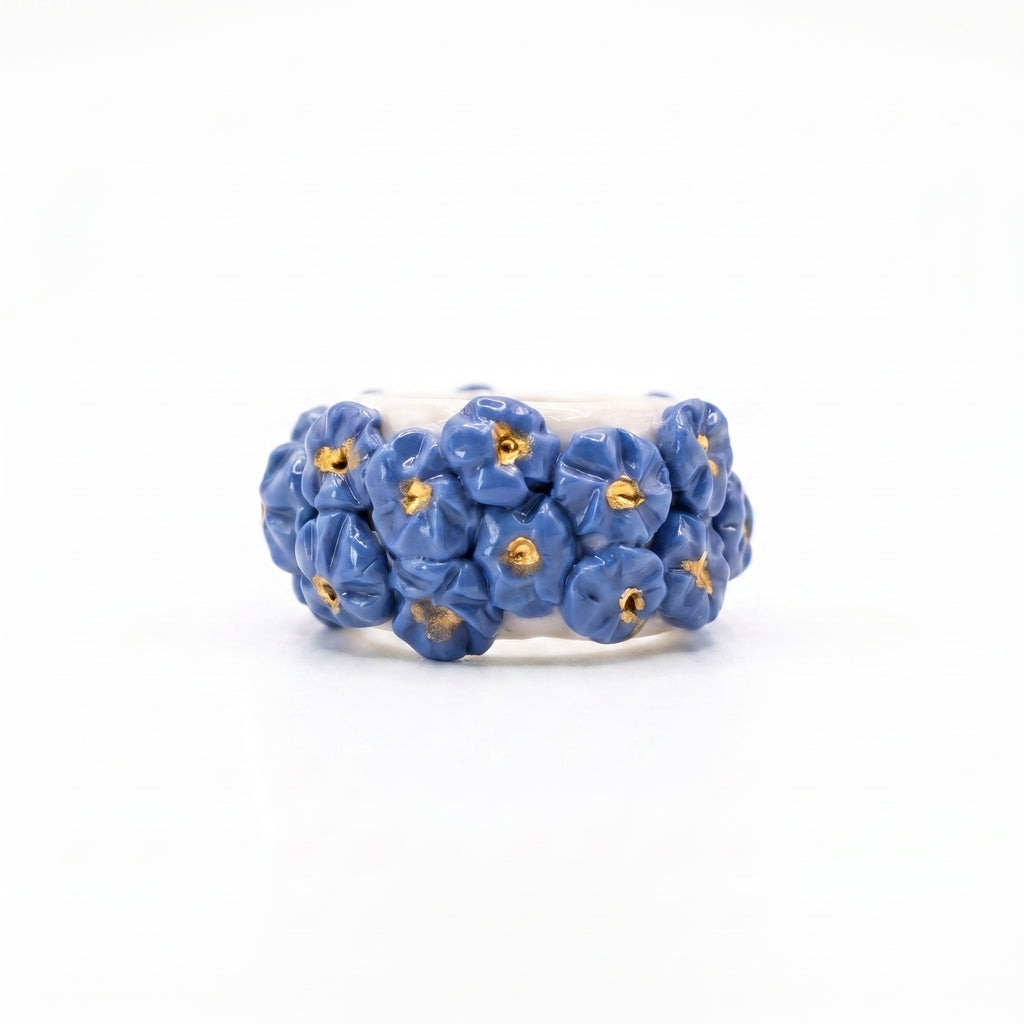 Bouquet Azul — anillo de porcelana con flores azul aciano modeladas a mano y pistilos de oro, vista frontal sobre fondo blanco