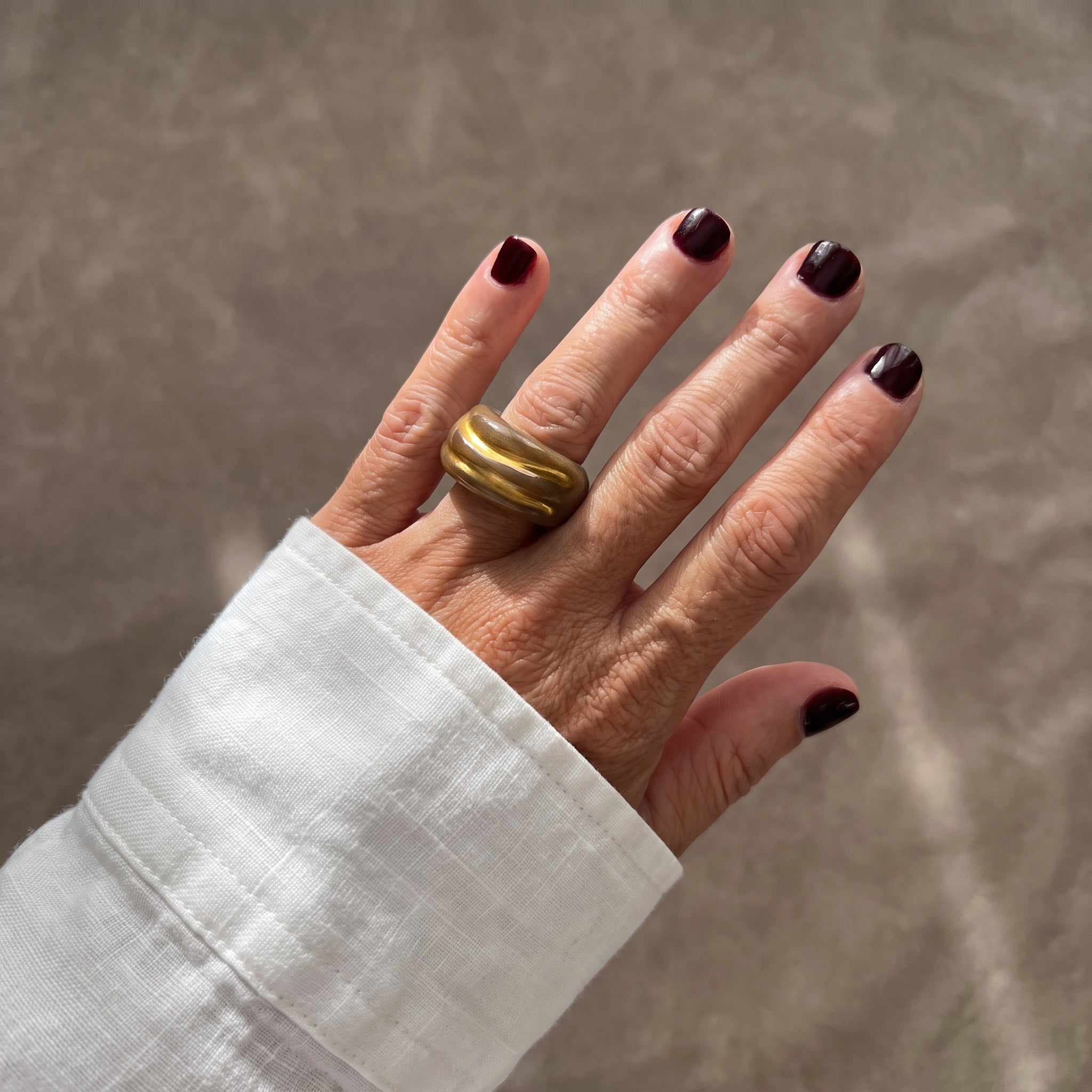 Onda Caramelo — anillo de porcelana con esmalte caramelo brillante y vetas doradas diagonales, vista frontal sobre fondo blanco mostrando las vetas de oro