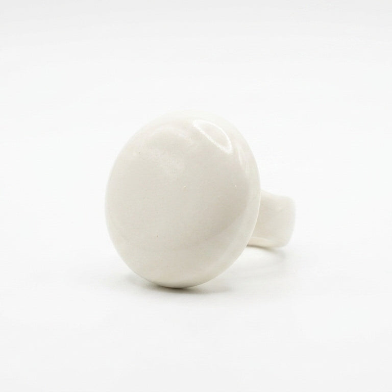 Esfera — anillo de porcelana blanca semiesférica sobre fondo blanco, vista lateral