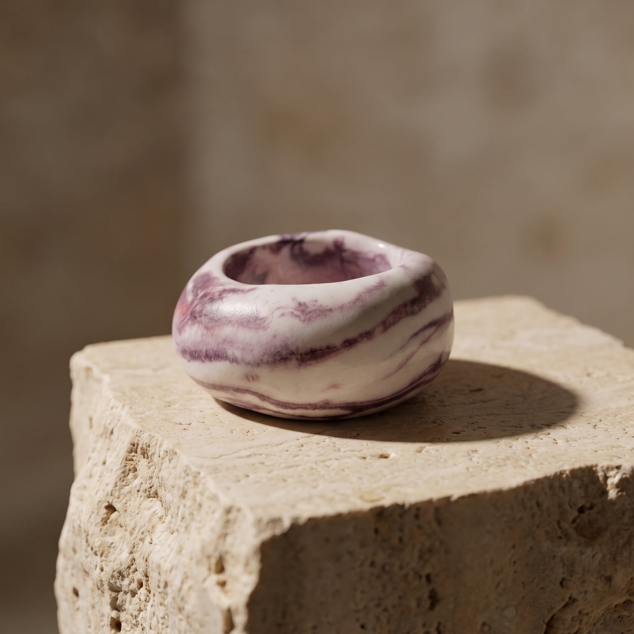 Petra Lilac — anillo de porcelana marmolada lila sobre piedra travertino con luz natural