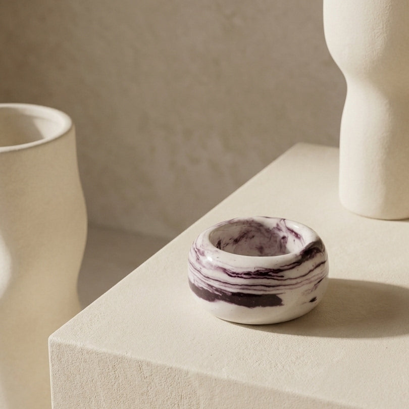 Petra Lilac talla 16 — anillo de porcelana marmolada lila sobre superficie beige con objetos cerámicos