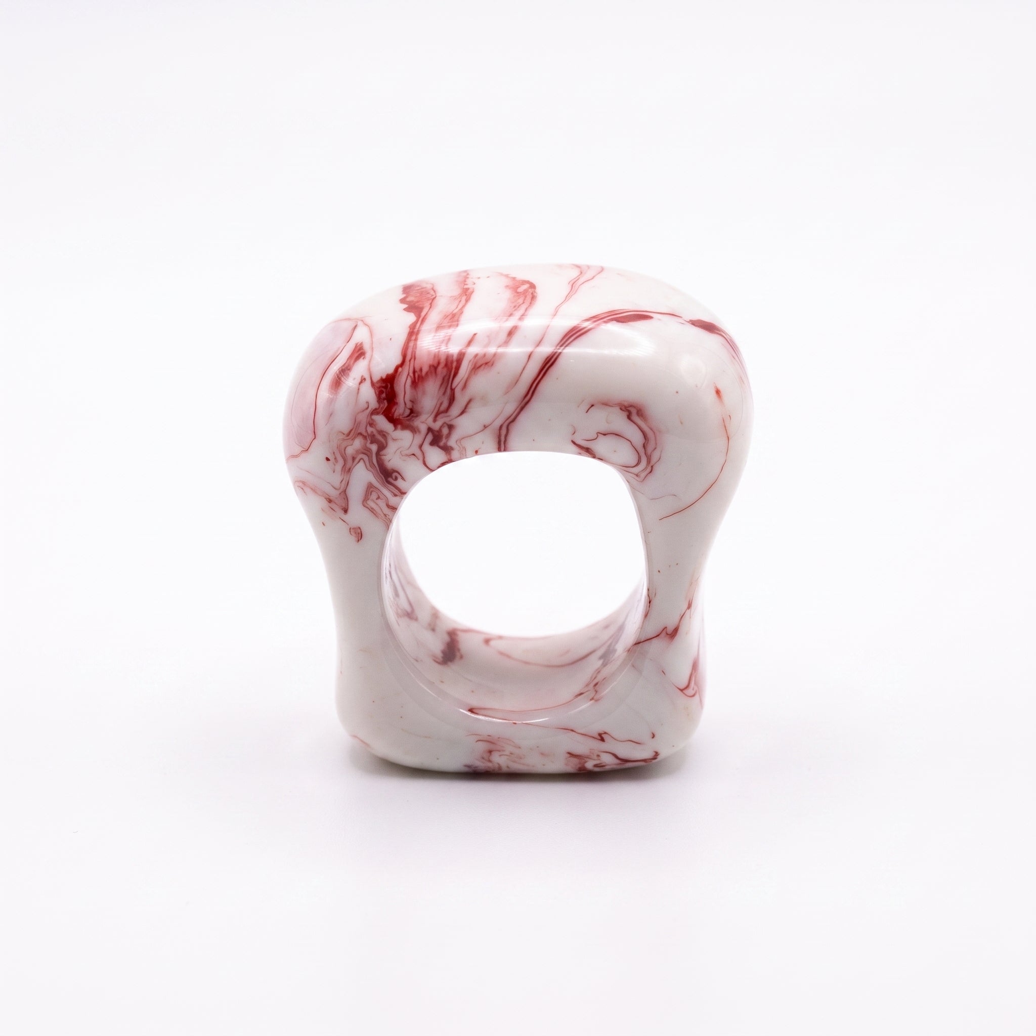 Petra Coral — anillo de porcelana blanca con vetas coral-rojo marmoladas, forma ancha y orgánica, vista frontal sobre fondo blanco