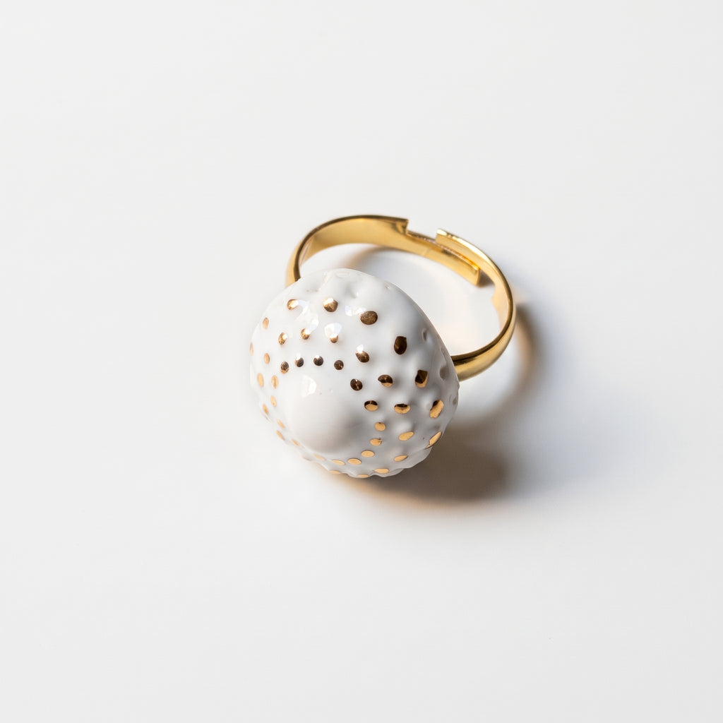 Girándola Blanco Oro S — anillo de porcelana blanca con puntos dorados y aro regulable dorado, vista de perfil sobre fondo blanco mostrando el ajuste del aro