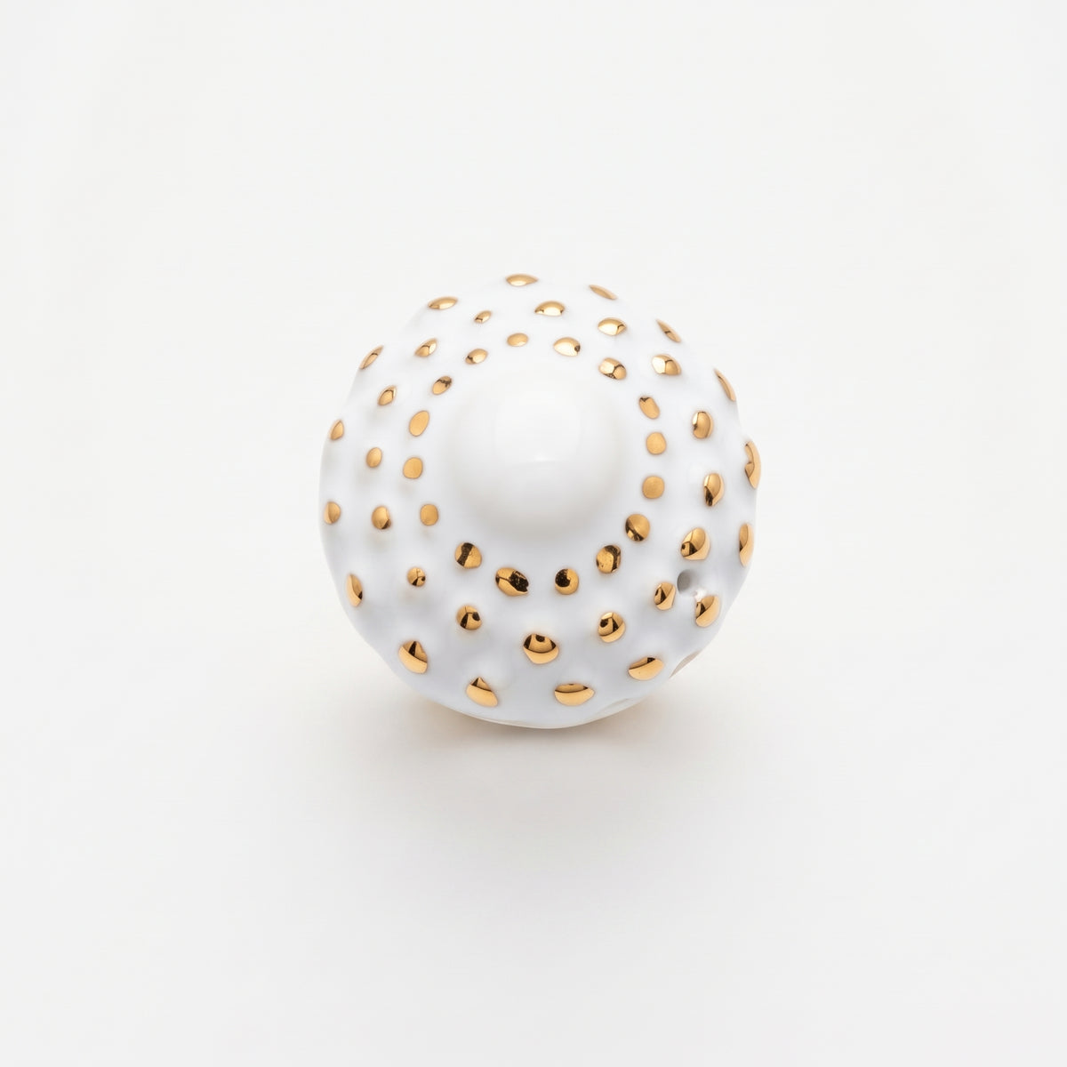 Girándola Blanco Oro S — anillo de porcelana blanca con puntos dorados excavados en la superficie sobre aro ancho dorado, vista frontal sobre fondo blanco